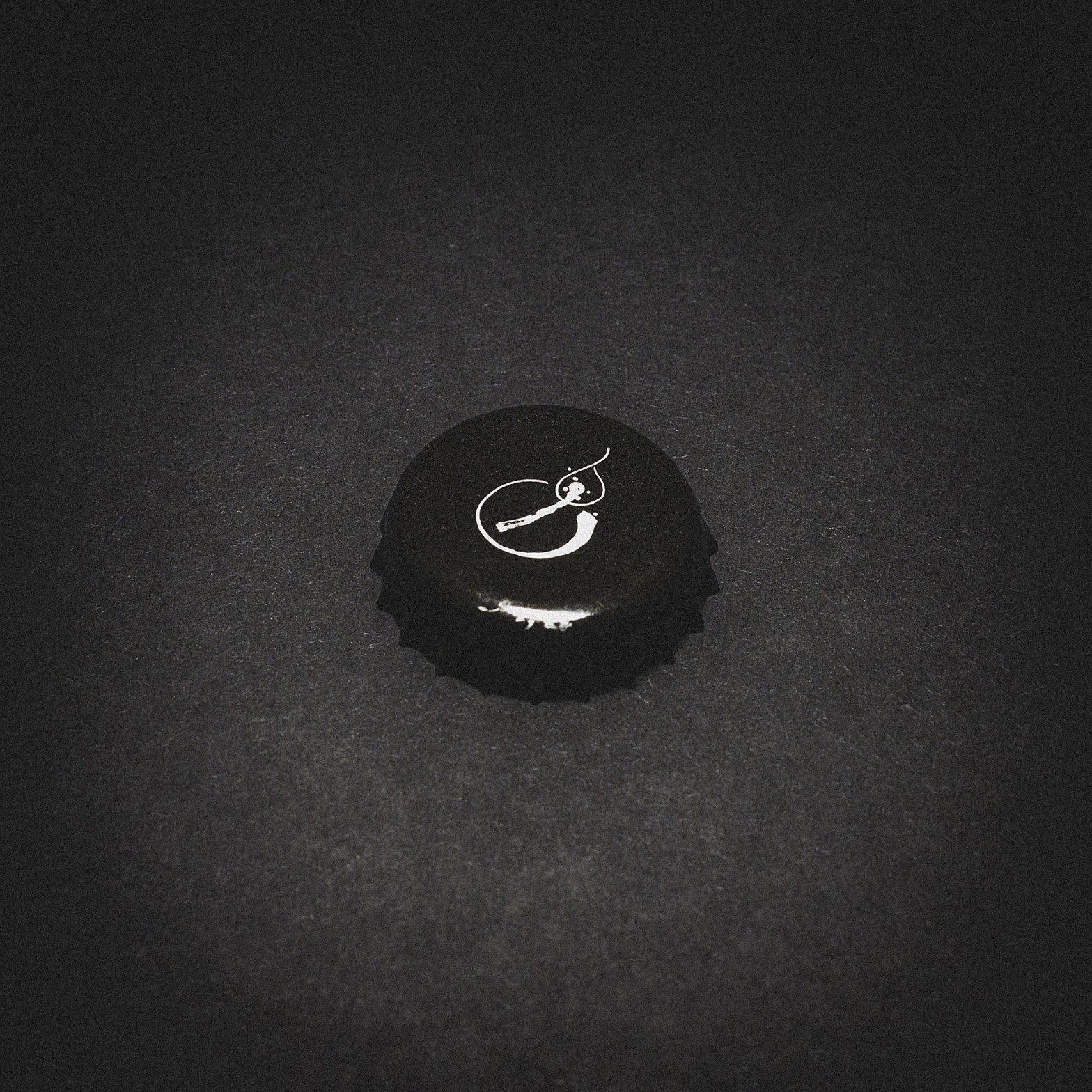 Bottle cap from Tete d'Allumette, set against a high-contrast black backdrop